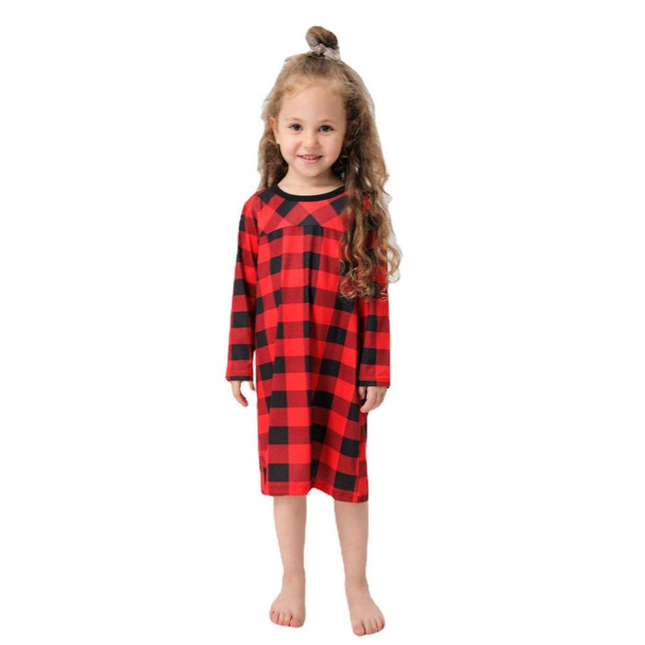 Child wearing a red and black checkered dress on a white background